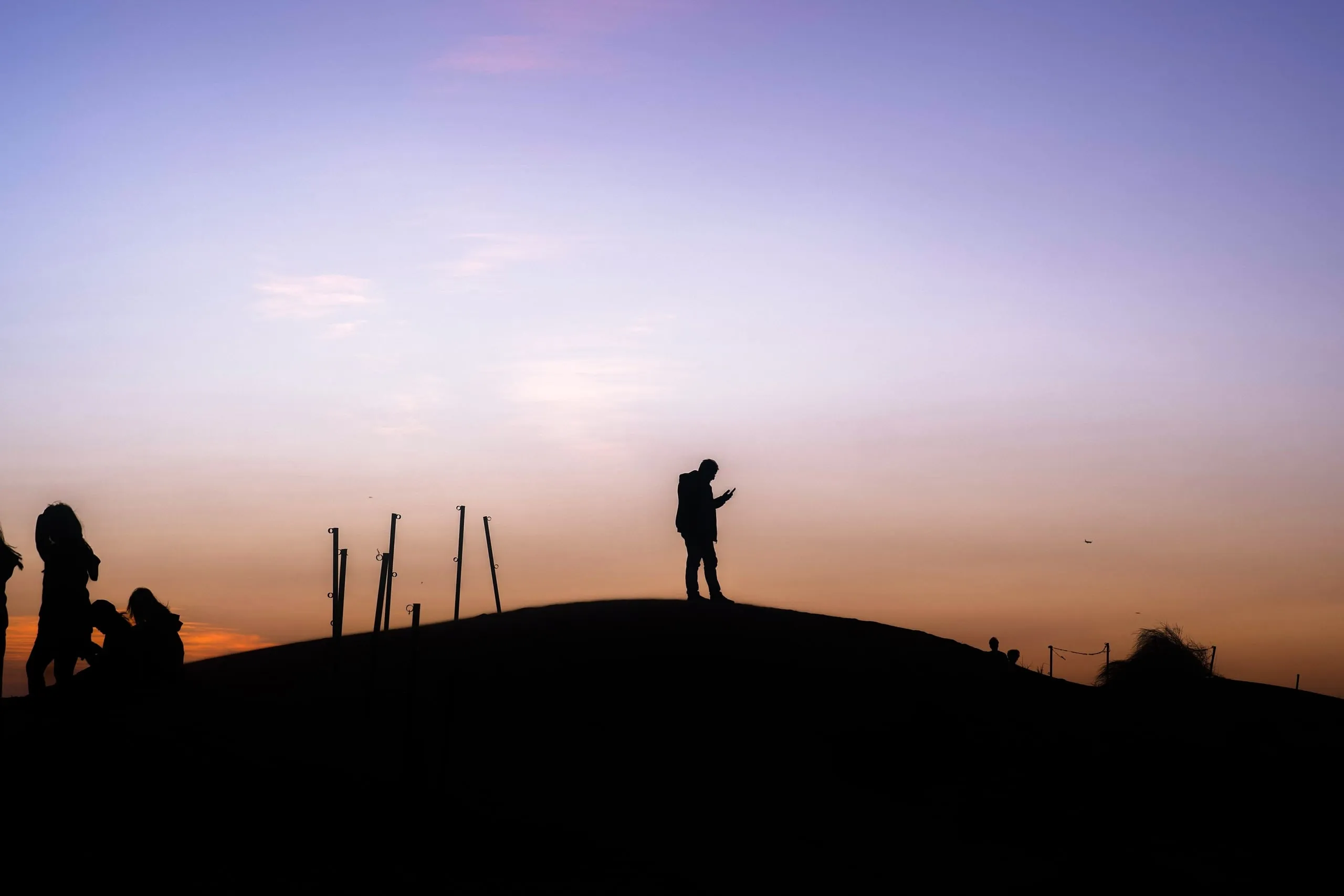 Dubai desert at dusk. The people on the ridge turned into silhouettes.