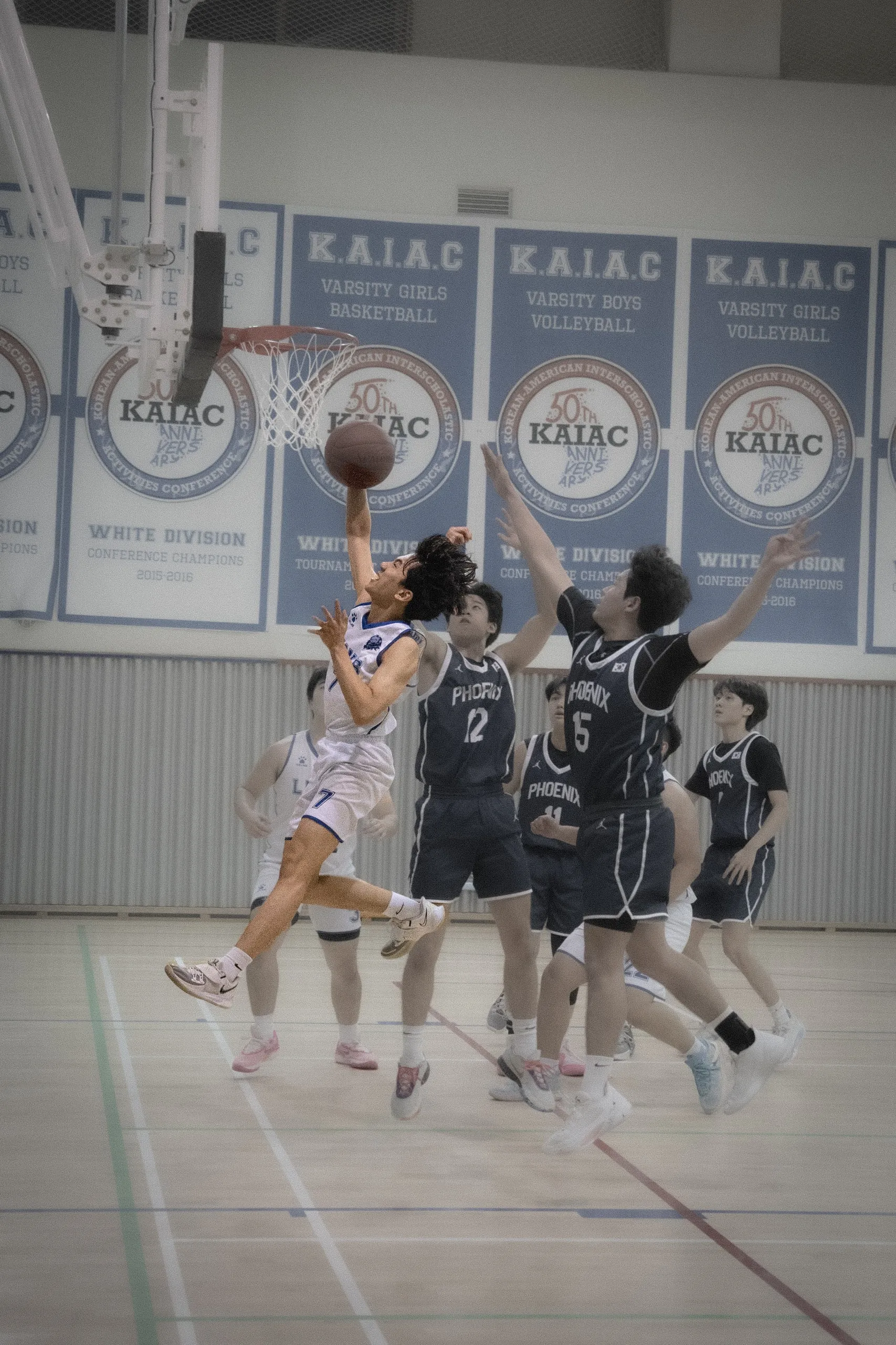 Another drive to the basket, under the KAIAC banners.