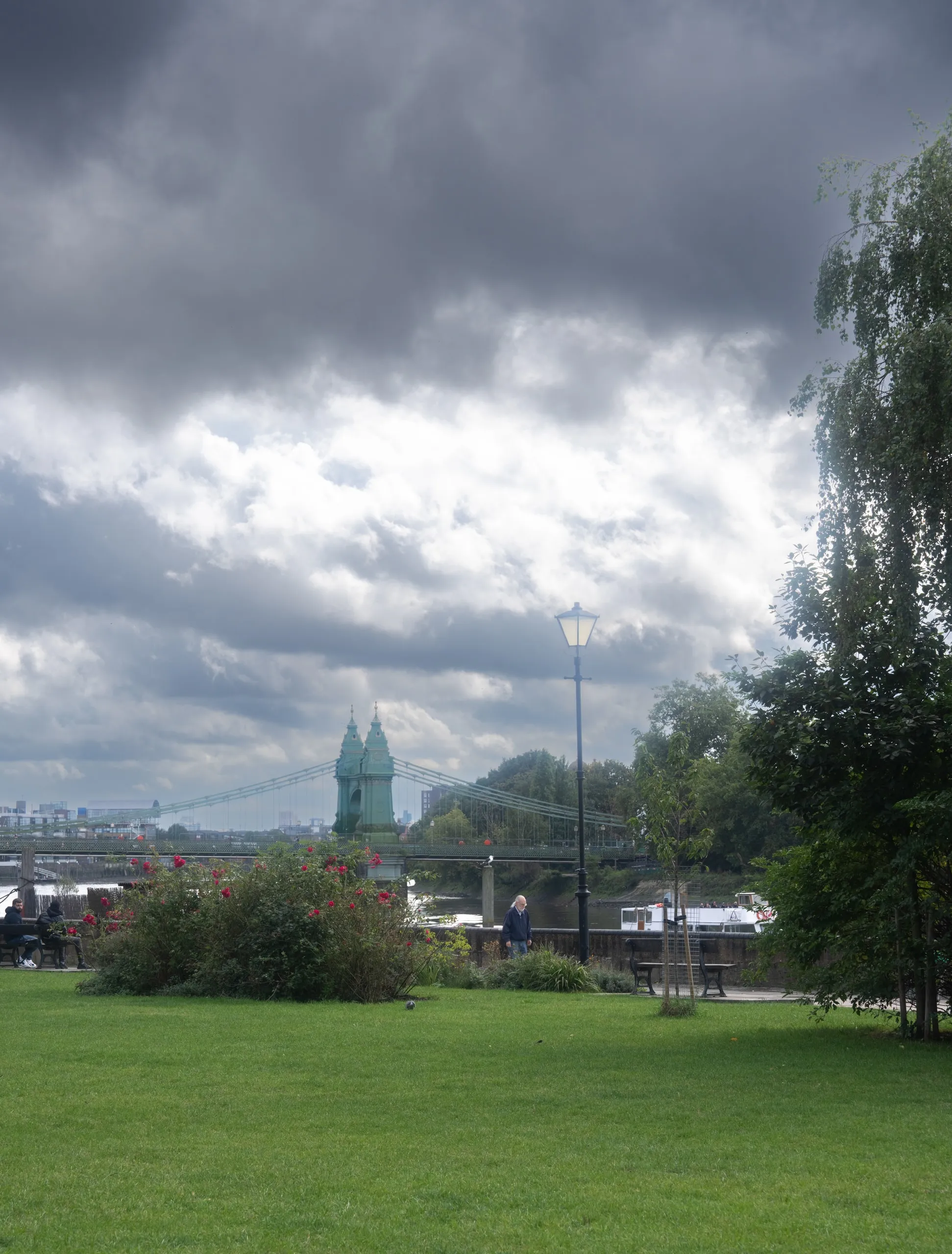 A London park under a heavy grey sky. The grass stays bright anyway.