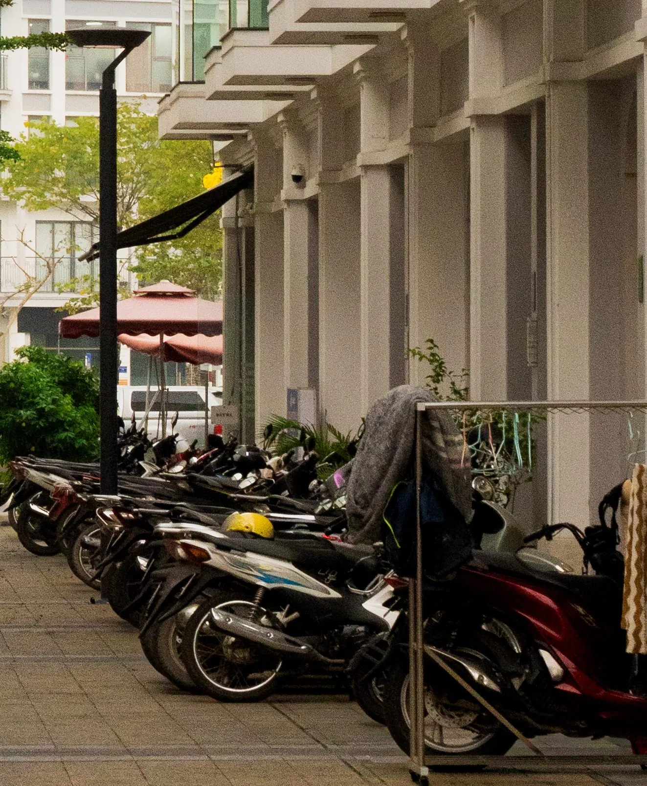 A row of scooters parked under the arcade.