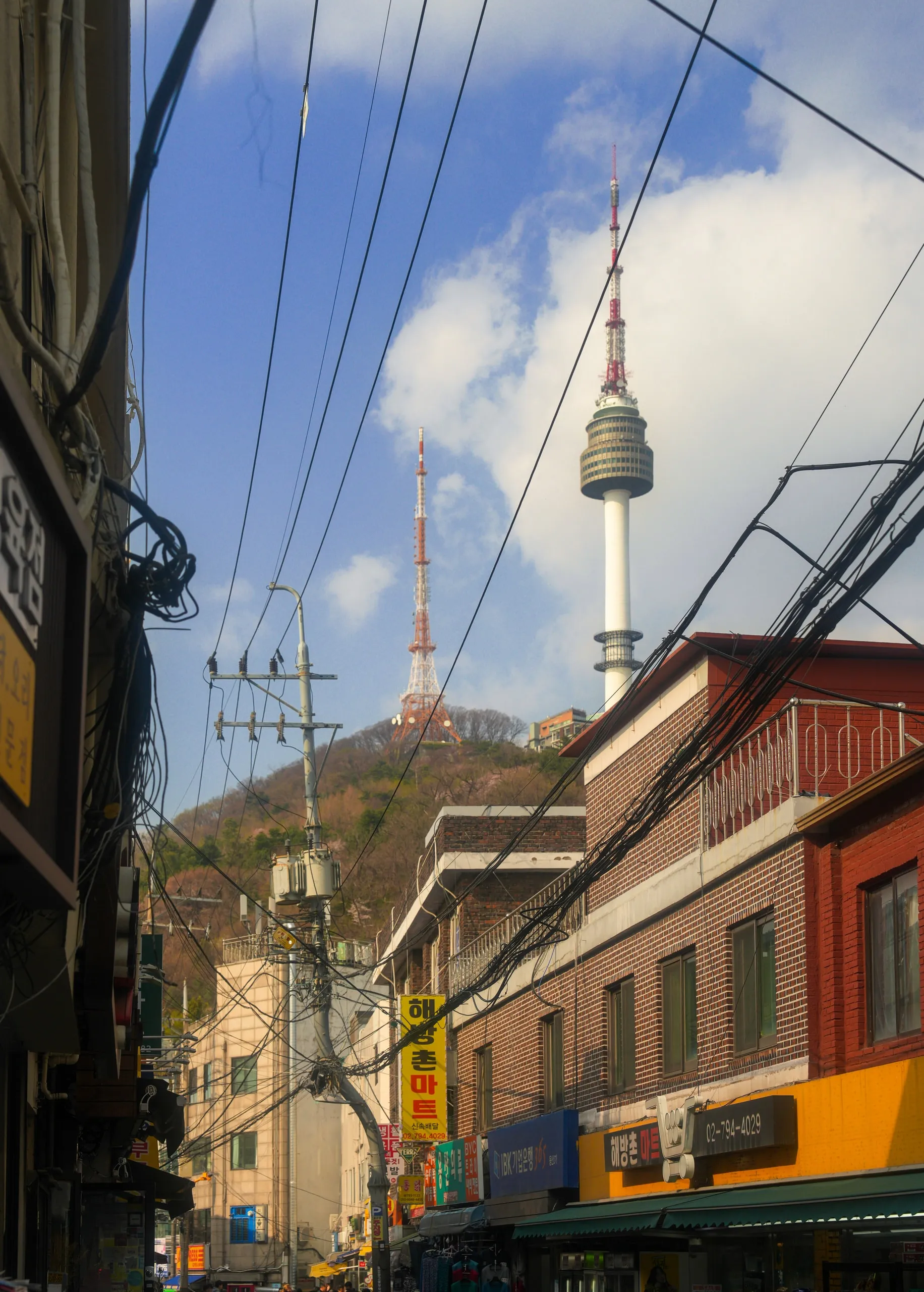 Seoul. Namsan Tower above the alley, wires cutting across the sky.