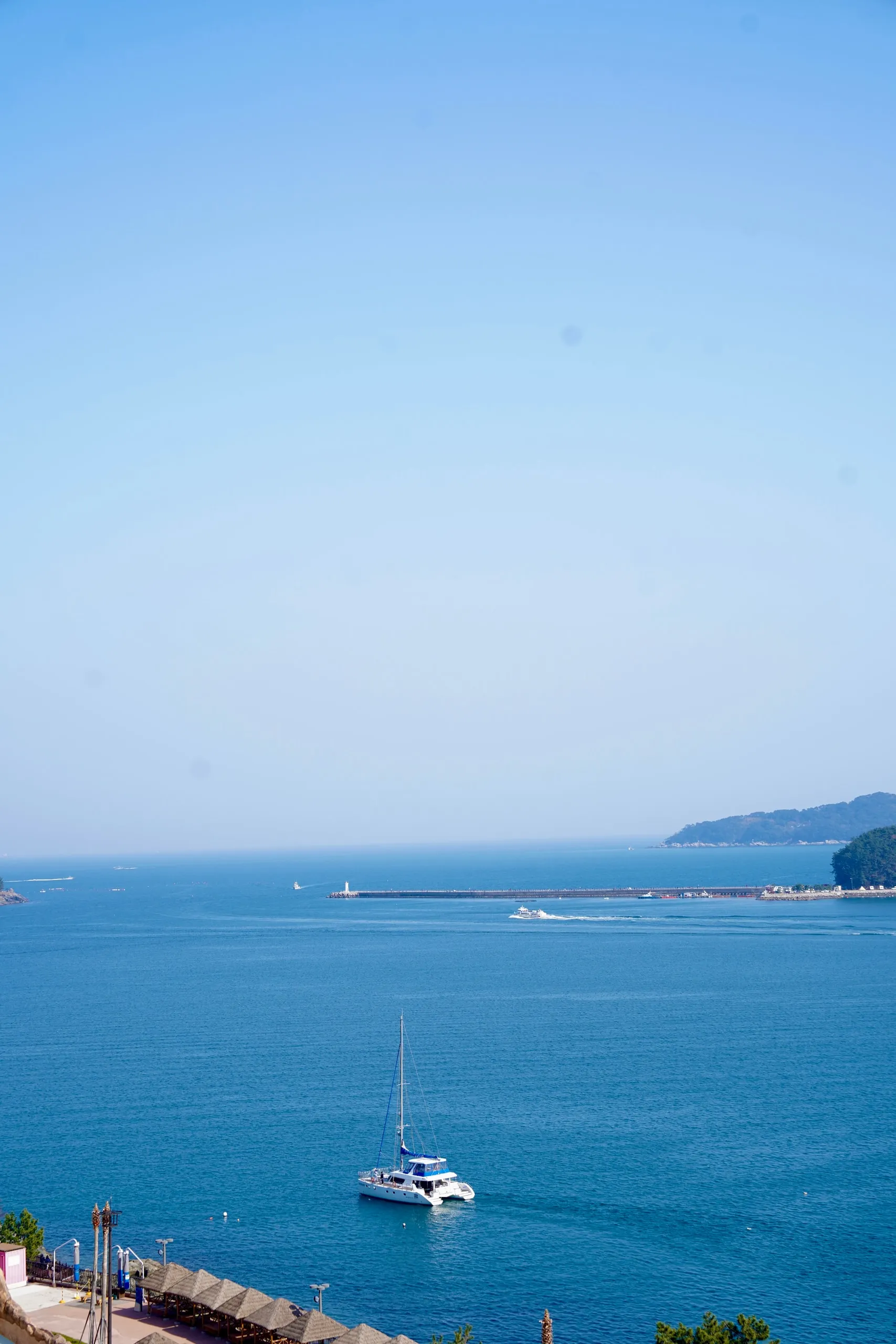 A white boat in a blue bay.